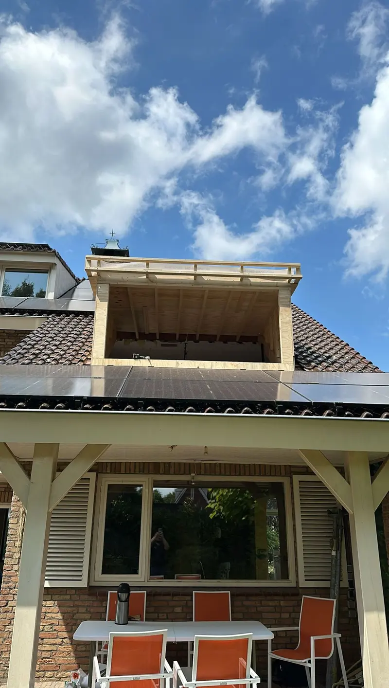 Dakkapel in aanbouw in Breda: houten casco geplaatst in het bestaande dakvlak, naast de zonnepanelen