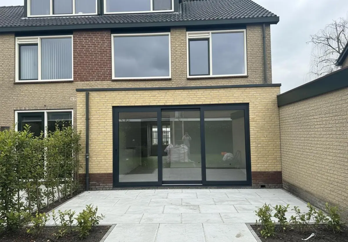 Uitbouw met schuifpui en aangelegd terras, gezien vanuit de tuin