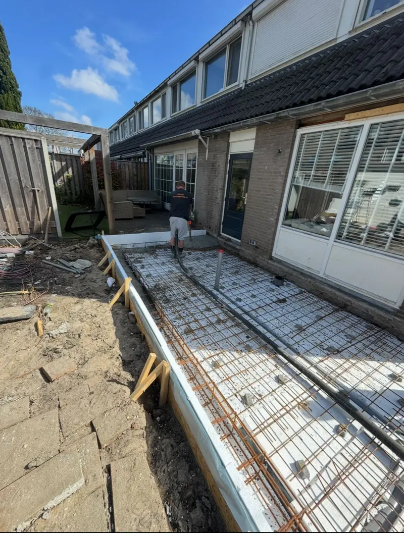 Fundering in aanbouw in Breda: bekisting, isolatie en wapeningsnetten aan de achtergevel, klaar voor het storten van de vloer
