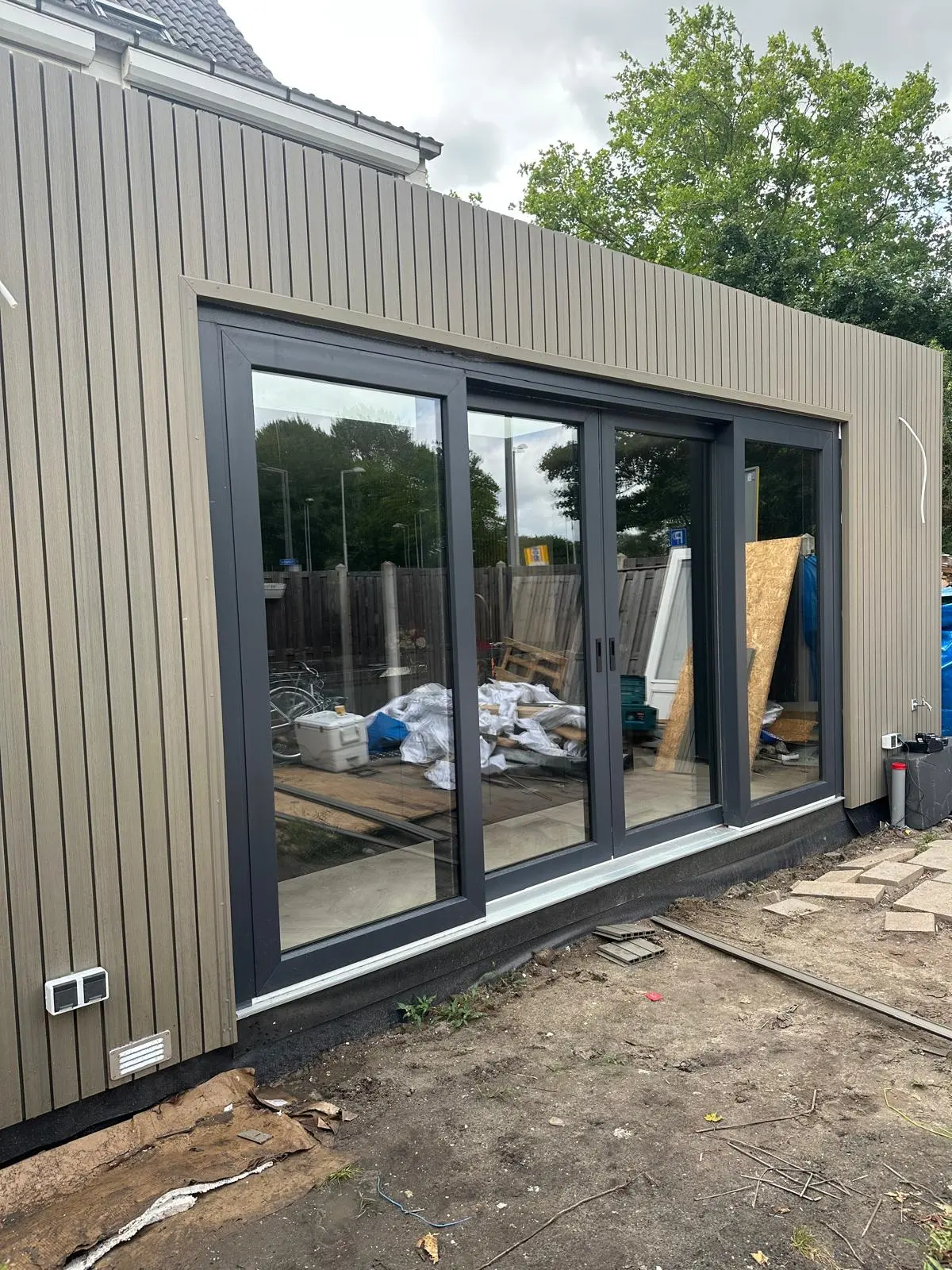 Plaatsing van een aluminium schuifpui in een nieuwe uitbouw