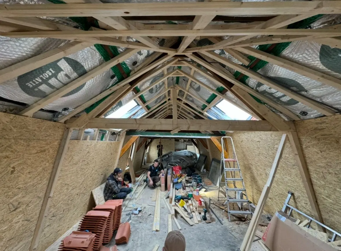 Zolderrenovatie in Rotterdam in uitvoering: nieuwe houten dakconstructie, PIR-isolatie tussen de spanten, OSB-wanden en twee dakramen